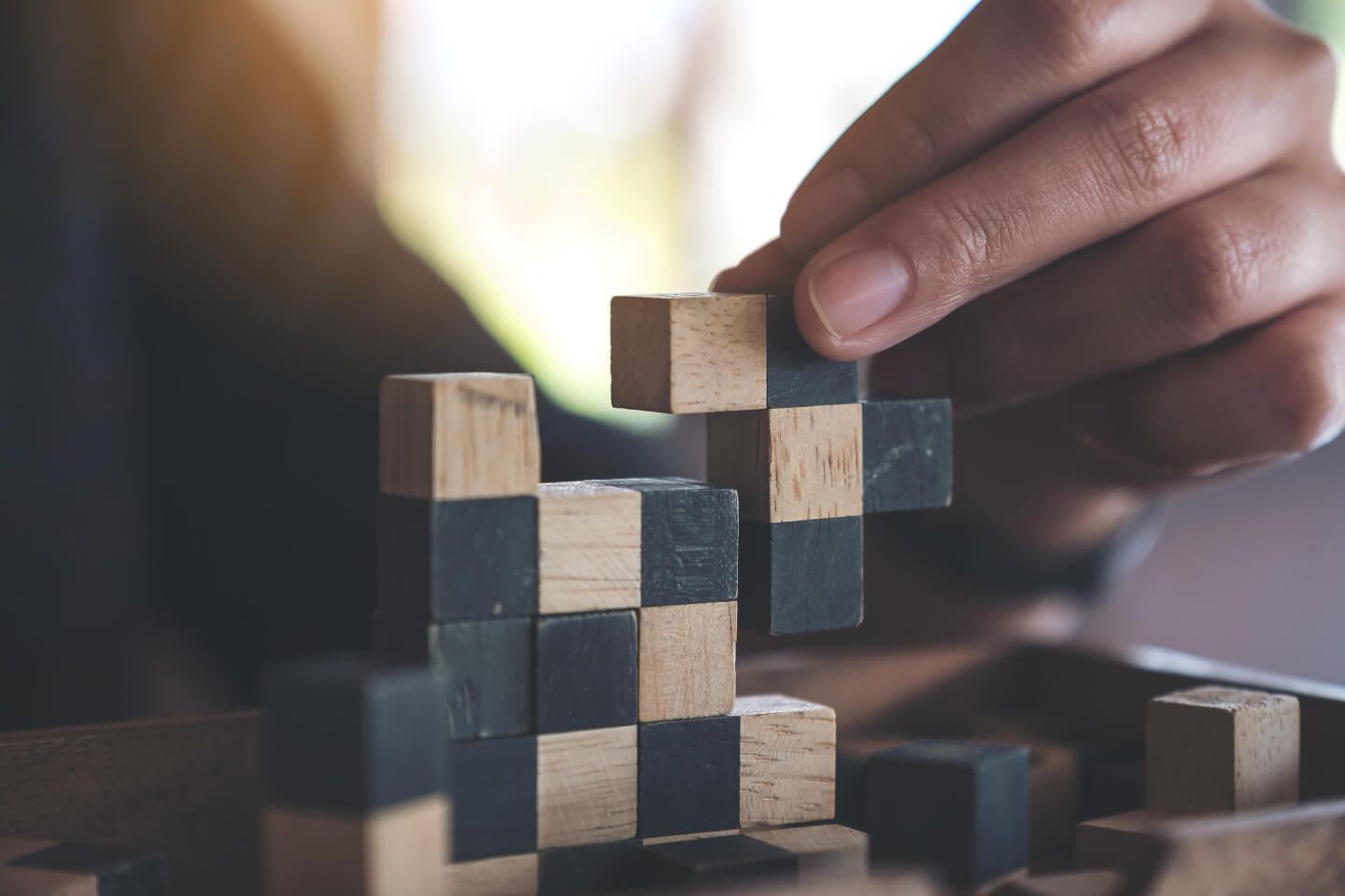 closeup image of people playing wooden tetris 2c3230df